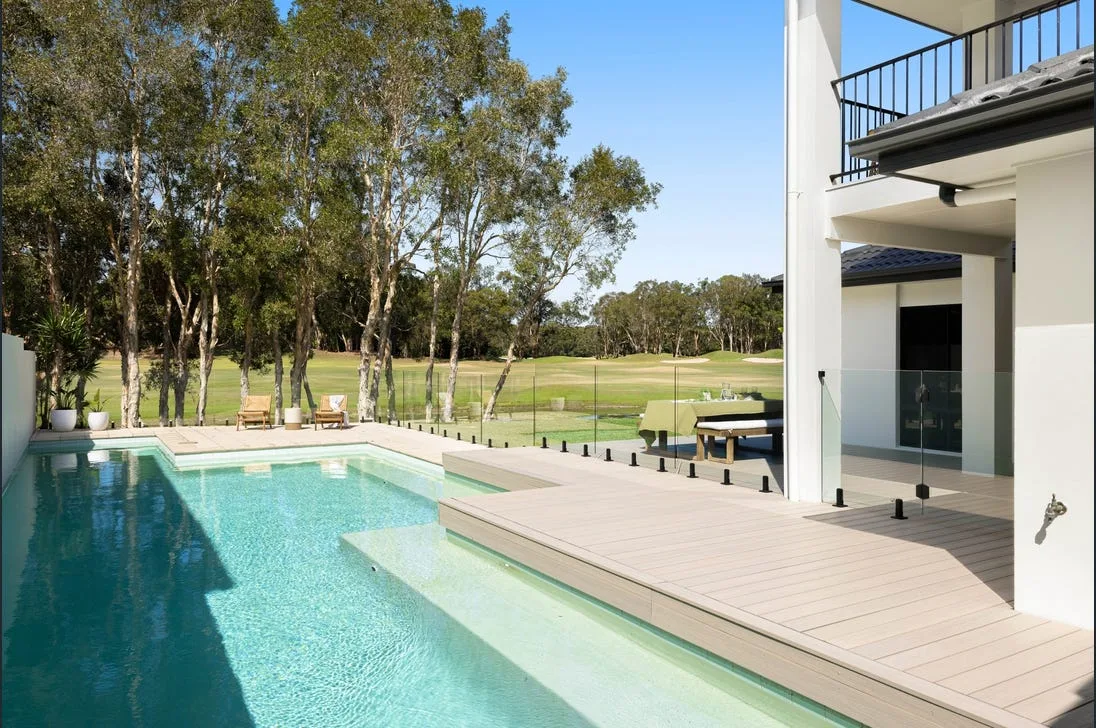 Frameless glass pool fencing beside a golf-course home